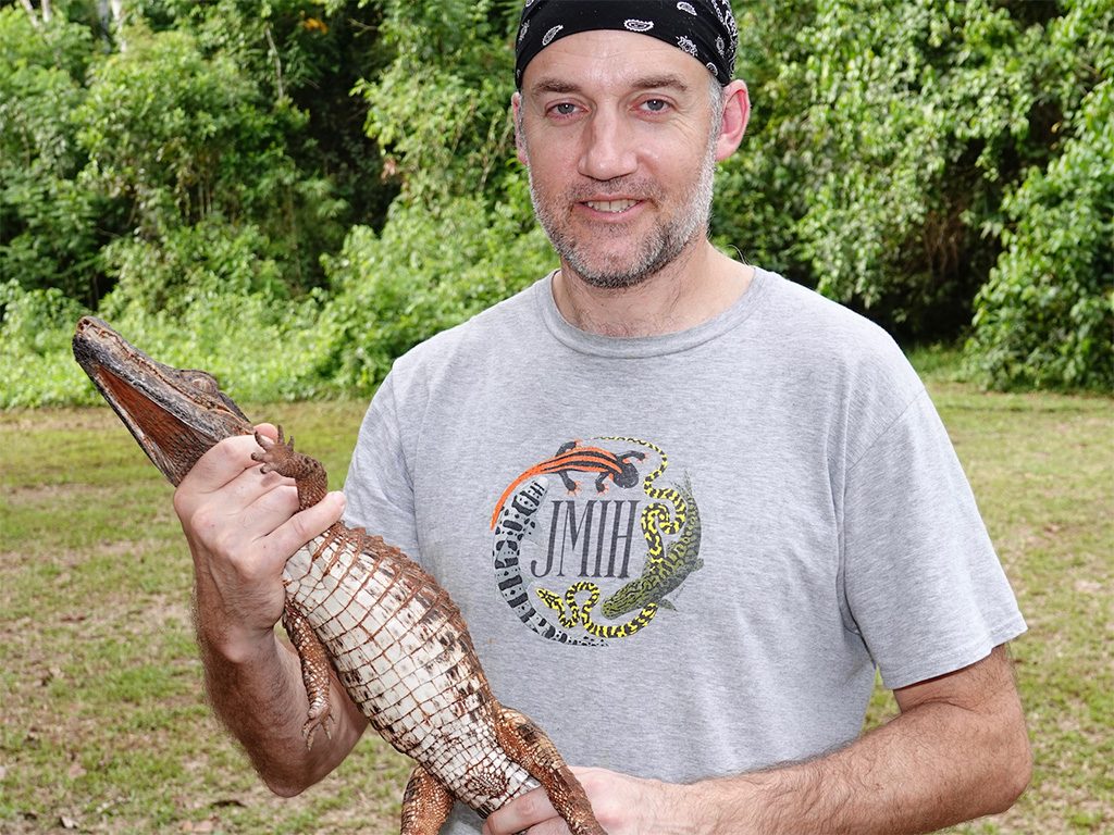 Dan Rabosky holding a caiman, studying reptile and amphibian biodiversity in the southern Peruvian Amazon. Image: Mark Cowan
