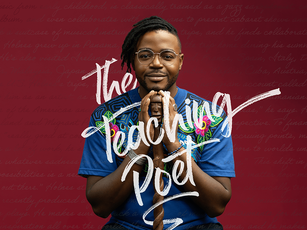 Darrel Alejandro Holnes, a man in a colorful shirt and glasses, sits looking directly at the camera, holding a beautifully carved wooden cane, in front of a maroon background, on which words are written in cursive. The words “The Teaching Poet” are centered and written in white.